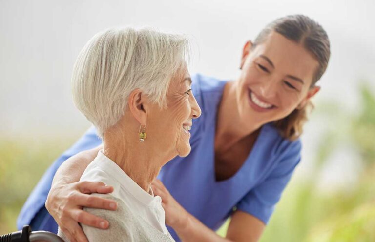 Two older adults and a staff member having a calm, engaged discussion in a welcoming common room.