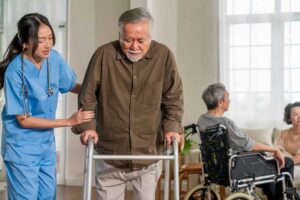 Family members review care documents with an assisted living resident at a dining table.