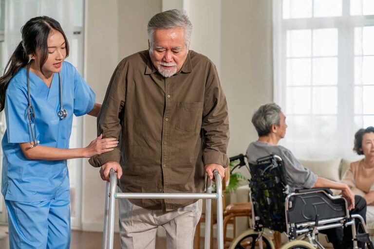 Family members review care documents with an assisted living resident at a dining table.